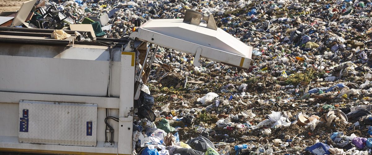 Truck unloading garbage on an open air dump. Waste recycling